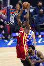 Atlanta Hawks' Clint Capela, left, dunks the ball past Philadelphia 76ers' Joel Embiid during the second half of Game 5 in a second-round NBA basketball playoff series, Wednesday, June 16, 2021, in Philadelphia. (AP Photo/Matt Slocum)