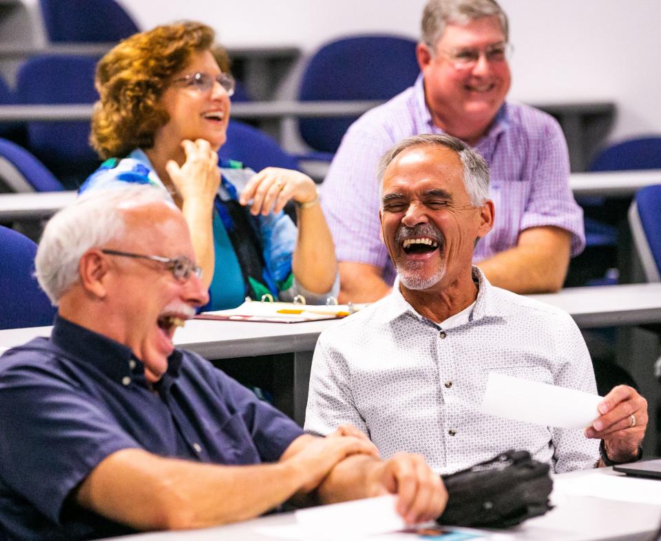 Pastors John Delcamp, left, with Shores Assembly and Pastor Lenny Cote of Church of the Springs, right, laugh while partaking in scenario Thursday after someone cracked a joke. Over 25 churches were represented during a meeting at the Ocala Police Department Thursday morning to learn about the CarePortal, which links churches to families in need.