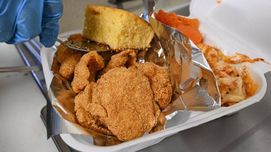 A fried catfish combo meal is boxed up with yams, mac & cheese and cornbread at Doll’s Kitchen which recently opened up in the shopping center southwest of the intersection of Shaw and Blackstone in Fresno.