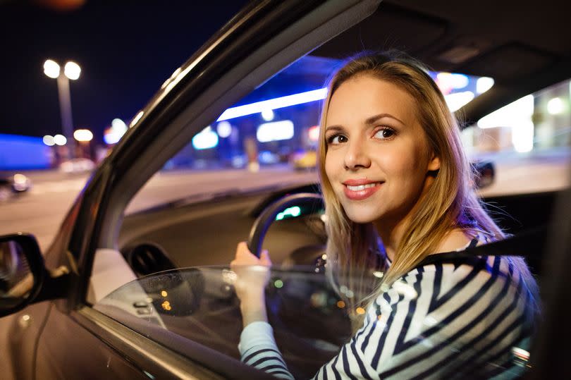 A woman driving her car at night