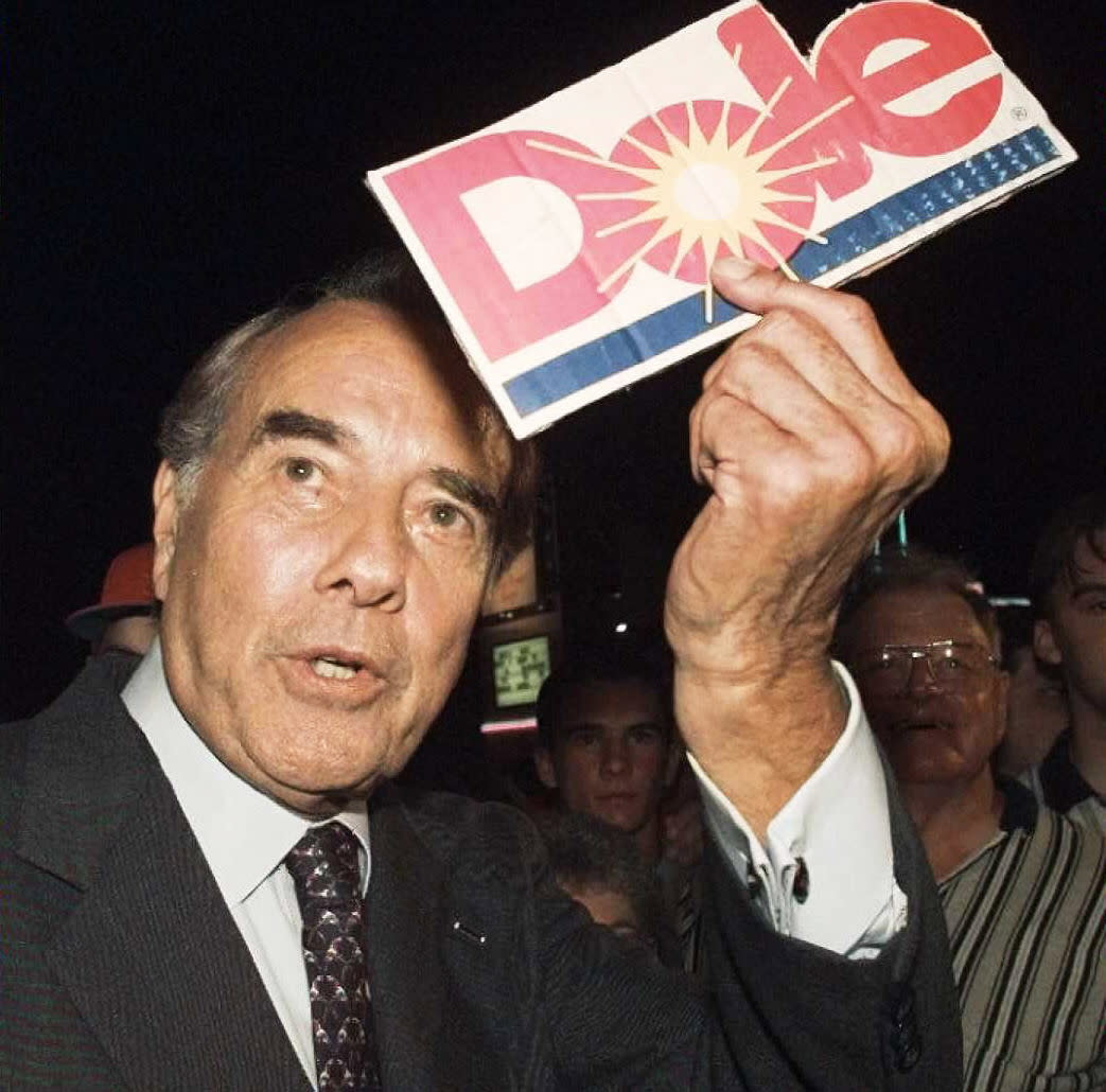 Republican presidential candidate Bob Dole holds a Dole pineapple sign given to him by a supporter outside of his hotel in Branson, Mo., on June 12, 1996. (David Ake / AFP via Getty Images file)