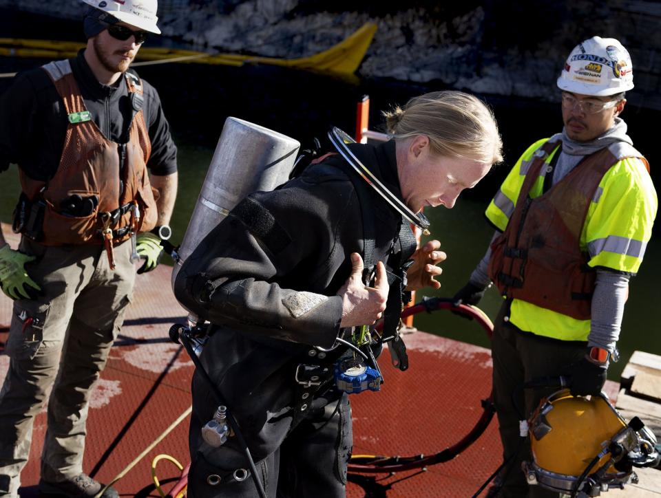 Underwater construction diver Christian Peterson, center, puts his gear on before entering the water to grout panels of the intake structure at the Deer Creek Intake Project in Heber City on Wednesday, Nov. 15, 2023. | Laura Seitz, Deseret News