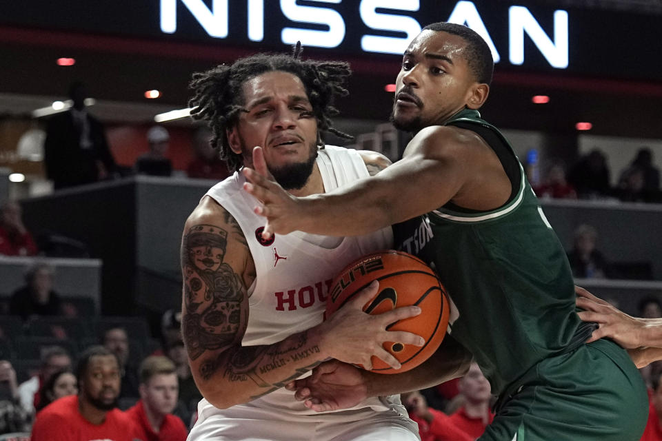 Houston's Emanuel Sharp, right, is fouled by Stetson's Stephan Swenson during the second half of an NCAA college basketball game Monday, Nov. 13, 2023, in Houston. (AP Photo/David J. Phillip)