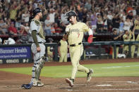 Arizona Diamondbacks' Corbin Carroll (7) scores a run in front of Detroit Tigers catcher Carson Kelly, left, during the sixth inning of a baseball game Saturday, May 18, 2024, in Phoenix. (AP Photo/Ross D. Franklin)