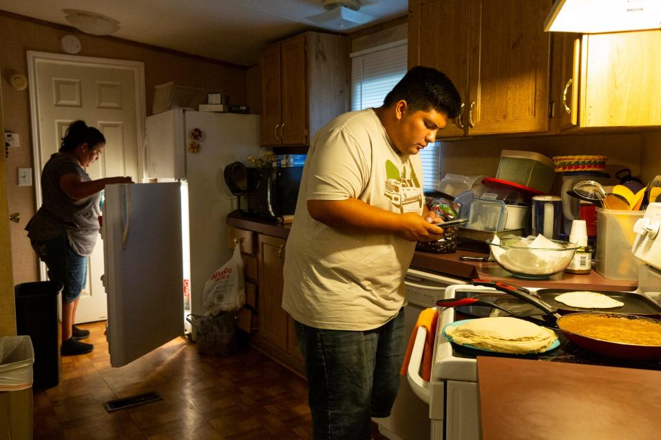 Carlos Medina helps his mother, Janneth Gonzalez, cook a meal for the family at home in Lake Dallas, Texas.