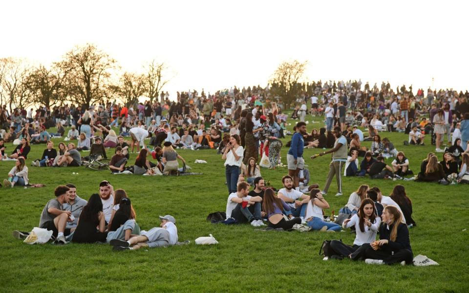 People enjoy the evening sunlight on Primrose Hill, north London, on Tuesday -  Ian West/PA