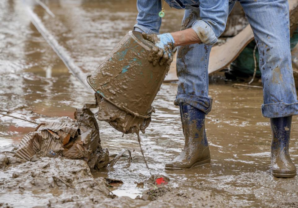 A person cleans mud from their home in Bad Neuenahr-Ahrweiler, Germany, Saturday, July 17, 2021. Due to strong rainfall, the Ahr river went over its banks and flooded big parts of the town. (AP Photo/Michael Probst)