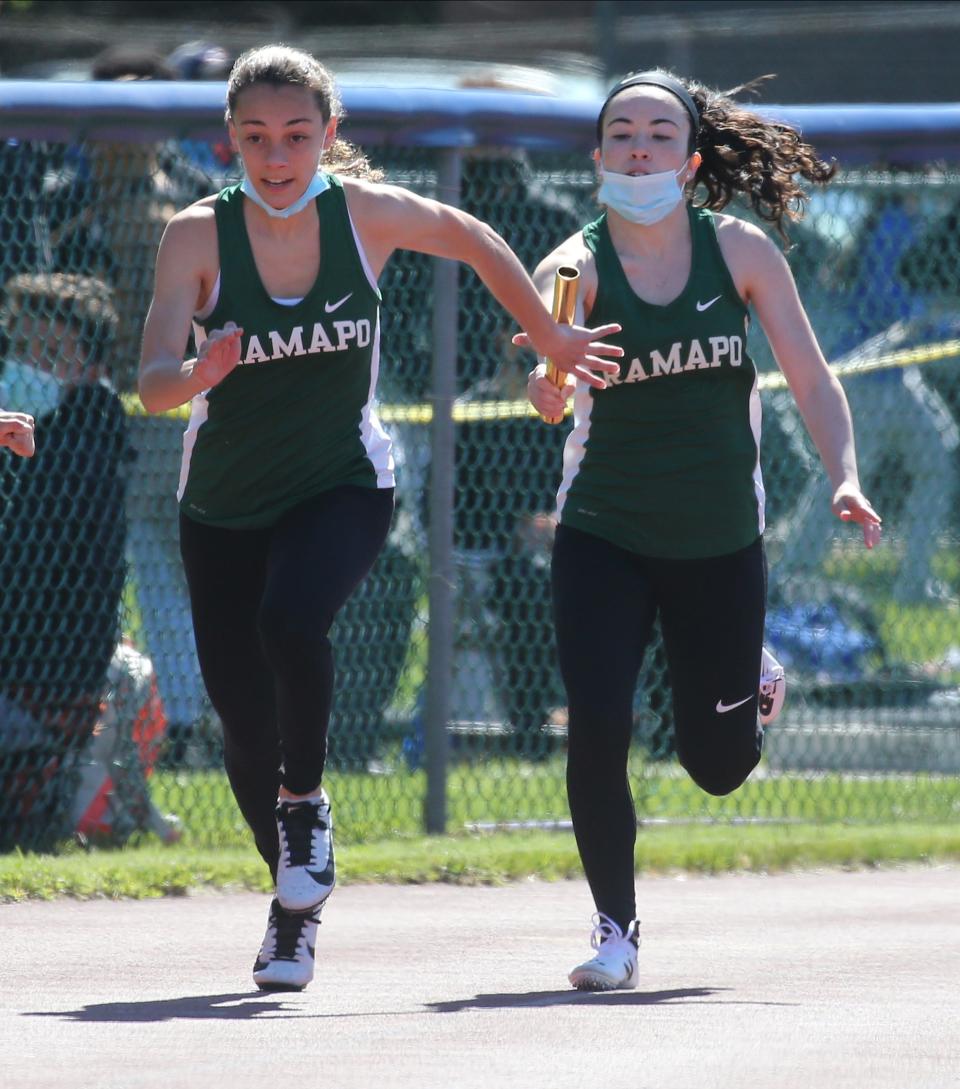 Izzie Anzaldo of Ramapo receives the baton from Courtney Lander in the 4x100 relays, part of the Comet Relays at Hackensack  on May 1,2021.