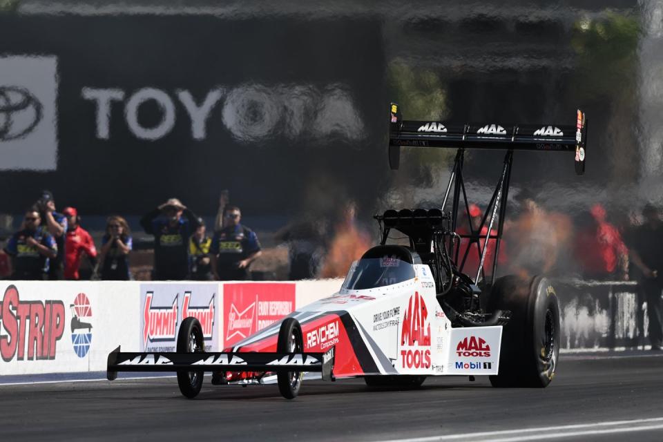 a race car on a track with a crowd watching