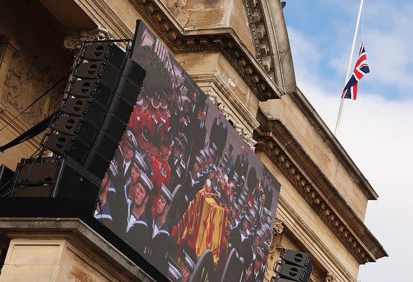 HULL, ENGLAND - SEPTEMBER 19:  Members of the public react as the funeral of Her Majesty Queen Elizabeth II is screened at Hull City Hall on September 19, 2022 in Hull, United Kingdom. Elizabeth Alexandra Mary Windsor was born in Bruton Street, Mayfair, London on 21 April 1926. She married Prince Philip in 1947 and acceded to the throne of the United Kingdom and Commonwealth on 6 February 1952 after the death of her Father, King George VI. Queen Elizabeth II died at Balmoral Castle in Scotland on September 8, 2022, and is succeeded by her eldest son, King Charles III. (Photo by Nigel Roddis/Getty Images)