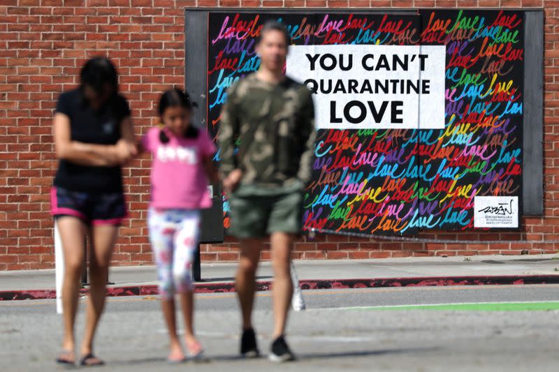 People walk in front of a mural, as the global outbreak of the coronavirus disease (COVID-19) continues, in Santa Monica