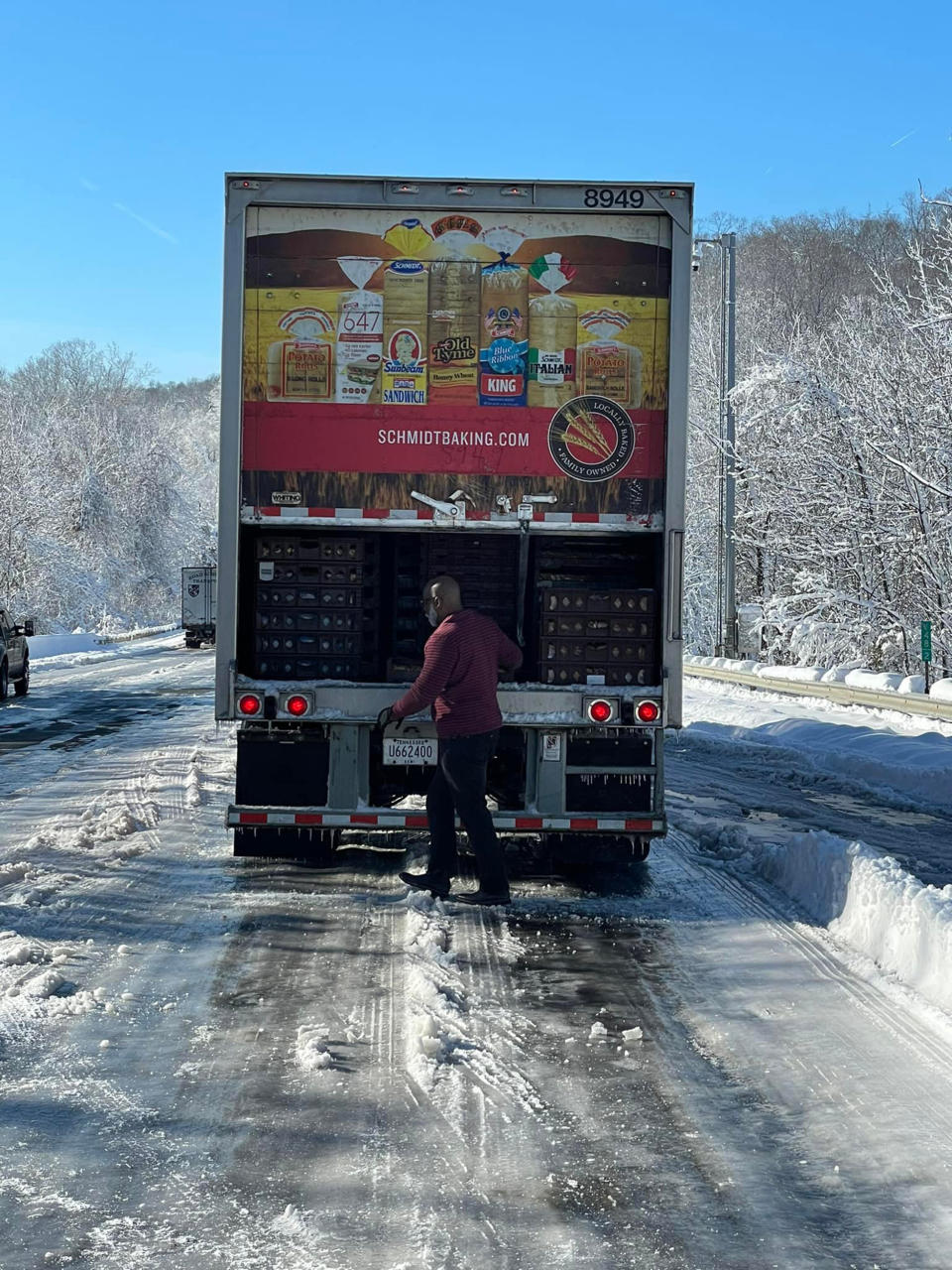 Ron Hill, a truck driver for Schmidt Baking Company, opened up the back of the truck to distribute loaves of bread and rolls to people stranded on icy I-95 in Virginia on Tuesday. (Casey Holihan Noe / Facebook)