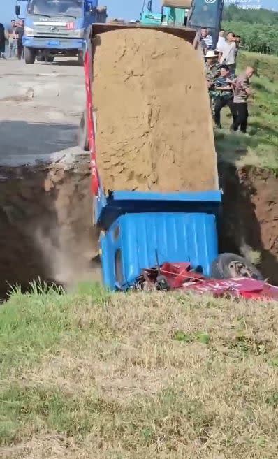 掛著紅色橫幅的卡車以「沉車裹頭」方式被填進了決堤口。（圖／翻攝自微博）