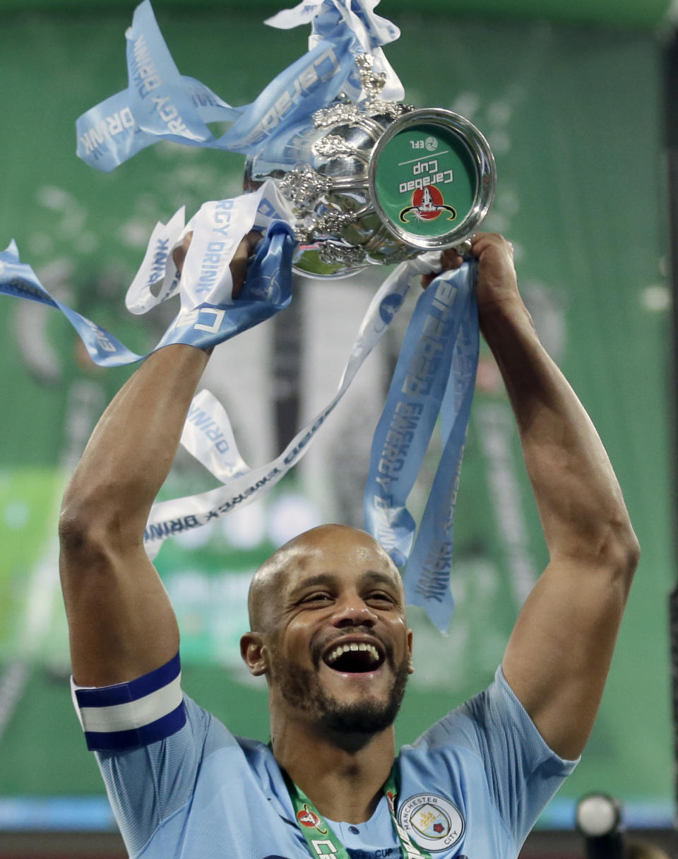 Manchester City's Vincent Kompany lifts the trophy after winning the English League Cup Final soccer match between Chelsea and Manchester City at Wembley stadium in London, England, Sunday, Feb. 24, 2019. (AP Photo/Tim Ireland)