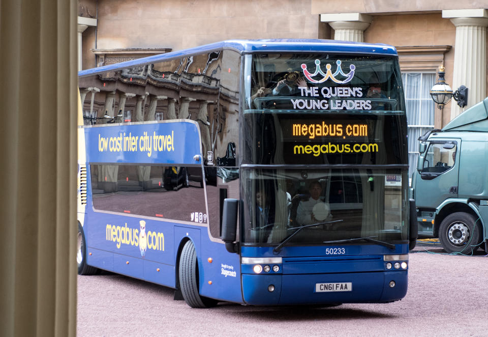 LONDON, ENGLAND - JUNE 29:  A Megabus arrives in the Quadrangle carrying this year's Queen's Young Leaders for the 2017 Queen's Young Leaders Awards Ceremony at Buckingham Palace on June 29, 2017 in London, England.  (Photo by Chris J Ratcliffe - WPA Pool/Getty Images)