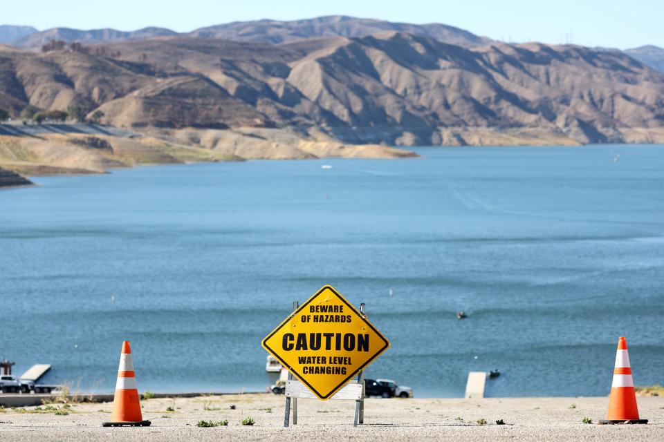 A caution sign is posted at the Castaic Lake reservoir in Los Angeles County, with hills scorched by the recent Route Fire in the distance, on October 4, 2022 in Castaic, California. The reservoir, part of the State Water Project, is currently at 35 percent capacity, below the historic average of 43 percent.