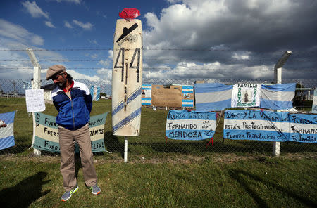 A man stands in front of signs in support of the 44 crew members of the ARA San Juan submarine missing at sea, placed on a fence outside the Argentine Naval Base where the submarine sailed from, in Mar del Plata, Argentina November 20, 2017. REUTERS/Marcos Brindicci