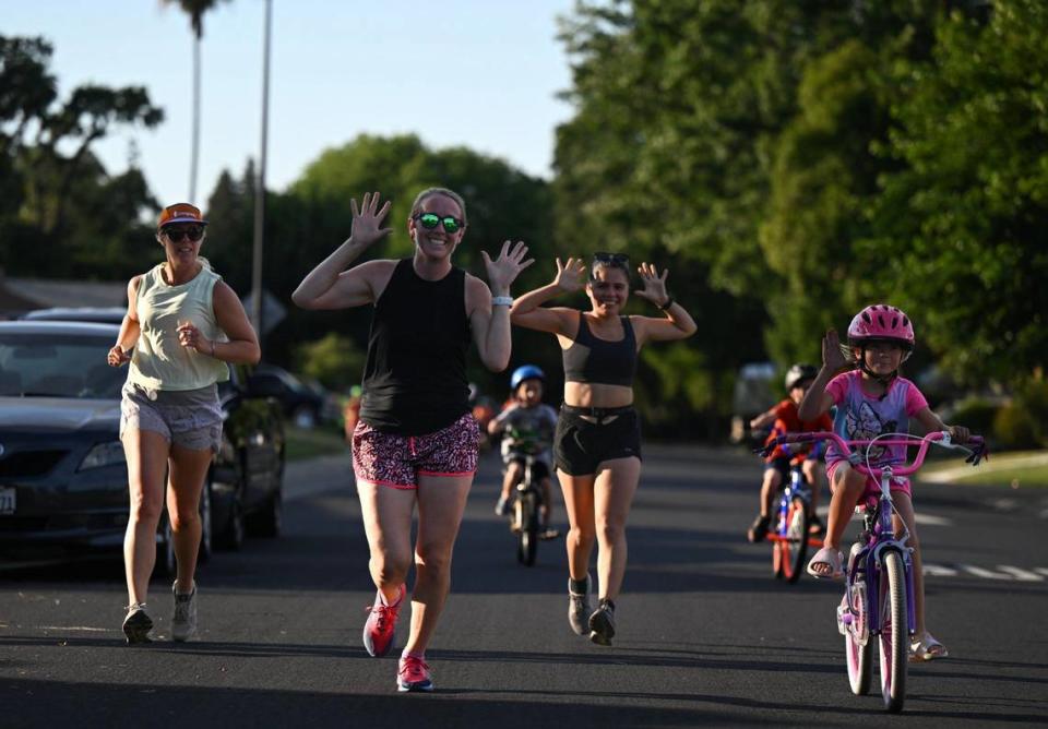 Members of the Sloppy Moose running club make their way down Deerwood Street in West Sacramento on June 20, 2024. The club’s three-mile run began and ended at Bike Dog Brewing Company.