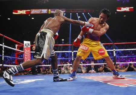 Floyd Mayweather, Jr. of the U.S. lands punch against Manny Pacquiao of the Philippines (R) in the ninth round during their welterweight WBO, WBC and WBA (Super) title fight in Las Vegas, Nevada, May 2, 2015. REUTERS/Steve Marcus