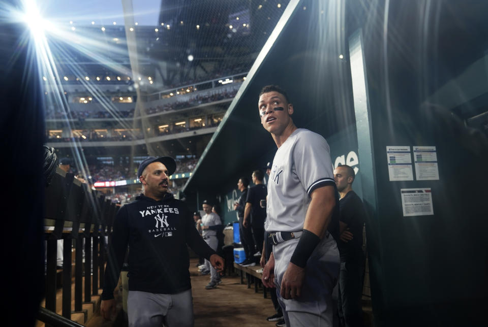 New York Yankees' Aaron Judge stands in the dugout after his solo home run during the first inning in the second baseball game of the team's doubleheader against the Texas Rangers in Arlington, Texas, Tuesday, Oct. 4, 2022. With the home run, Judge set the AL record for home runs in a season at 62, passing Roger Maris. (AP Photo/LM Otero)