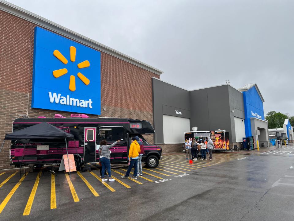 Walmart associates line up at food trucks outside the newly remodeled Supercenter in Henderson on Friday. The $6 million project included repainting store entrances with bolder colors.