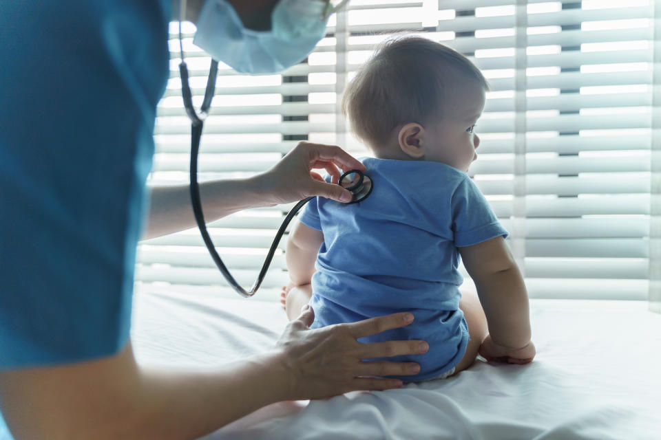 Asian female Pediatrician doctor examining her little baby patient with stethoscope in medical room at hospital.