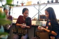 Anna (C), 11, and Yuna Cheung (R), 11, from Great Britain hold hedgehogs as their mother Kimberly Russel watches at the Harry hedgehog cafe in Tokyo, Japan, April 5, 2016. In a new animal-themed cafe, 20 to 30 hedgehogs of different breeds scrabble and snooze in glass tanks in Tokyo's Roppongi entertainment district. Customers have been queuing to play with the prickly mammals, which have long been sold in Japan as pets. The cafe's name Harry alludes to the Japanese word for hedgehog, harinezumi. REUTERS/Thomas Peter