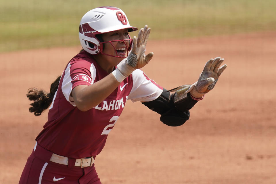 Oklahoma's Tiare Jennings celebrates as she runs toward home plate with a home run against James Madison in the first inning of an NCAA Women's College World Series softball game Sunday, June 6, 2021, in Oklahoma City. (AP Photo/Sue Ogrocki)