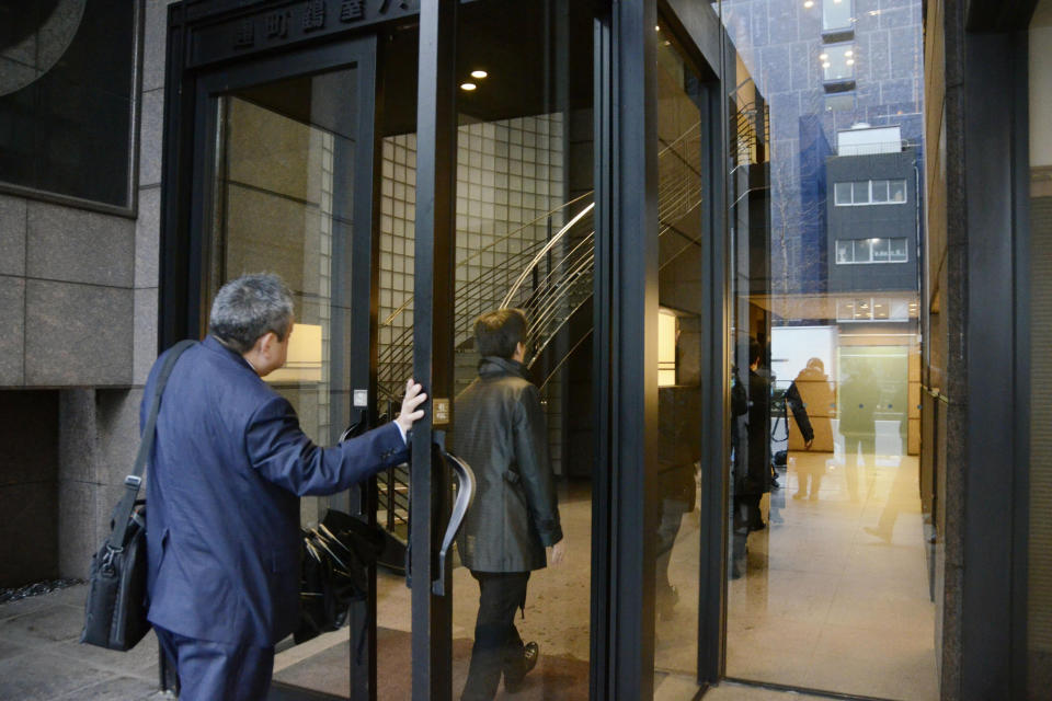 Tokyo prosecutors enter a building where the office of Junichiro Hironaka, a Japanese lawyer of former Nissan Chairman Carlos Ghosn, is located, in Tokyo Wednesday, Jan. 8, 2020. Prosecutors raided Hironaka's office where Ghosn had visited regularly before skipping bail last week and fleeing to Lebanon. Ghosn was under strict bail conditions while preparing for his trial on financial misconduct allegations. But he had been allowed to use a computer at his lawyer's office under those conditions. (Kyodo News via AP)