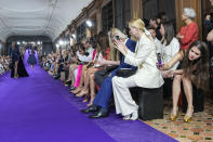 A spectator, right, uses a cell phone to record the Mabille Haute Couture Fall/Winter 2022-2023 fashion collection presented Tuesday, July 5, 2022 in Paris. (AP Photo/Michel Euler)