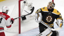 Boston Bruins goaltender Tuukka Rask (40), of Finland, for the puck after a save as Carolina Hurricanes' Justin Williams, left, tries to knock in the rebound during the first period in Game 1 of the NHL hockey Stanley Cup Eastern Conference finals, Thursday, May 9, 2019, in Boston. (AP Photo/Charles Krupa)