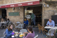 People eat in a restaurant as restrictions are eased following months of government-imposed shutdowns, in Tel Aviv, Israel, Sunday, March 7, 2021. Israel reopened most of its economy Sunday as part of its final phase of lifting coronavirus lockdown restrictions, some of them in place since September. (AP Photo/Ariel Schalit)