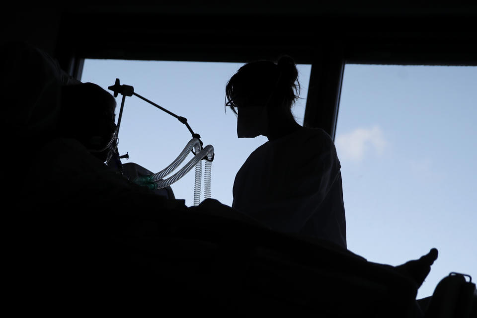 A nurse tends to a patient affected by the COVID-19 virus in the ICU unit at the Charles Nicolle public hospital, Thursday, April 15, 2021 in Rouen, France. A renewed crush of COVID-19 cases is again forcing intensive care units across France to grapple with the macabre mathematics of how to make space for thousands of critically ill patients (AP Photo/Christophe Ena)