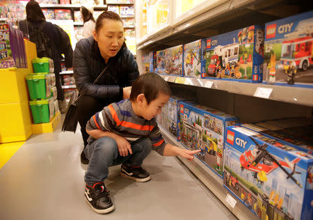 FILE PHOTO: A boy looks at Lego boxes next to his mother at a Lego store in Beijing, China January 13, 2018. REUTERS/Jason Lee/File Photo