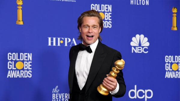 Brad Pitt sosteniendo un Globo de Oro (Imagen: GQ)