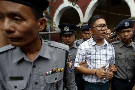 Detained Reuters journalist Wa Lone is escorted by police officers at Insein court in Yangon, Myanmar July 16, 2018. REUTERS/Ann Wang