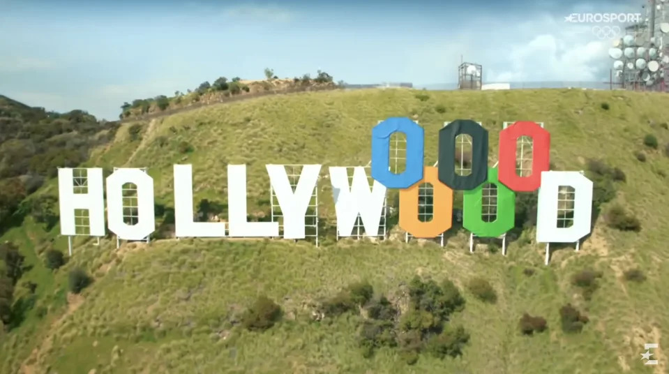 The Hollywood sign altered for the Olympics, with the "OO" letters replaced by Olympic rings in blue, yellow, black, green, and red