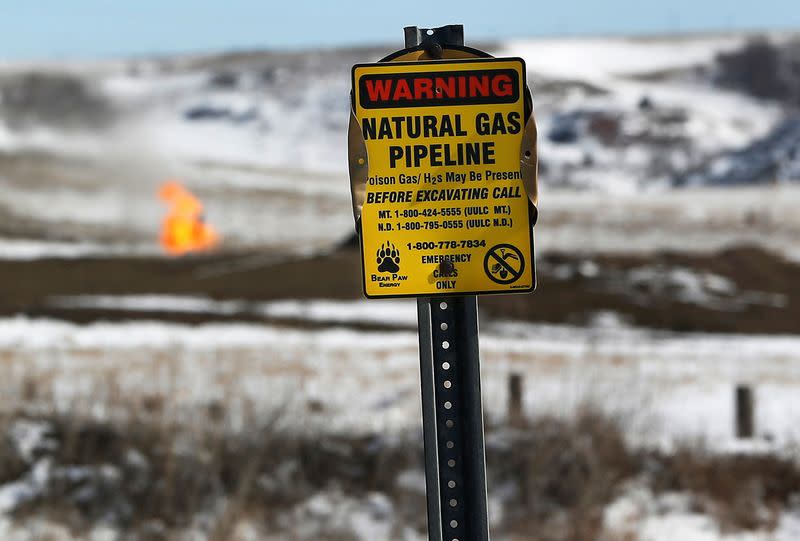 FILE PHOTO: A warning sign for a natural gas pipeline is seen at an oil pump site outside of Williston, North Dakota