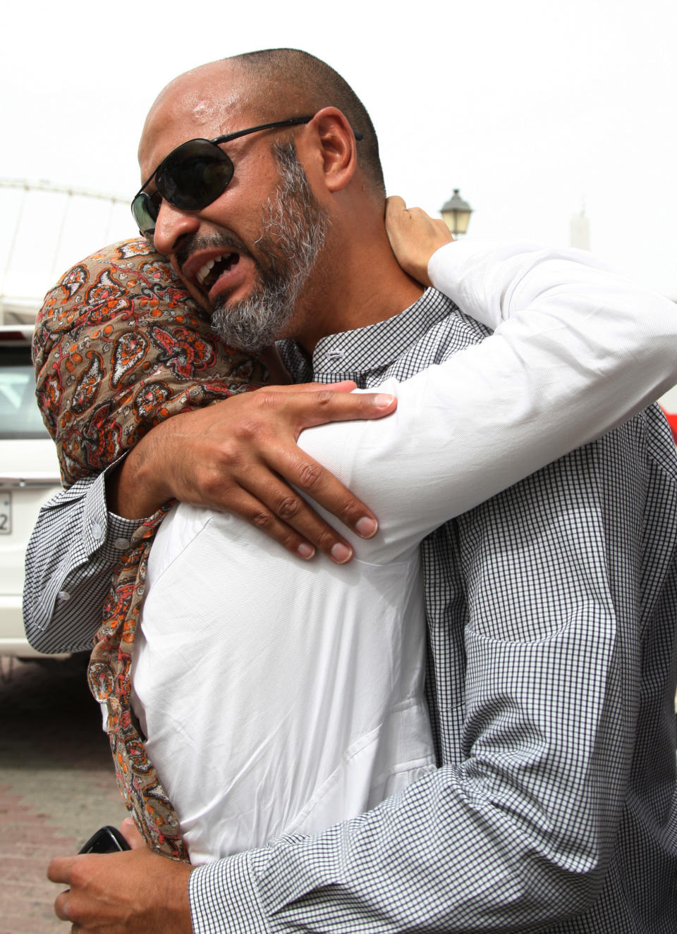 The father of a child killed after a fire took hold of the Villaggio Mall, in Doha's west end is comforted in the Qatari capital of Doha Monday May 28, 2012. Qatar's Interior Ministry said 13 children were among 19 people killed in a fire that broke out at one of the Gulf state's fanciest shopping mall on Monday. The Villaggio opened in 2006 and is one of Qatar's most popular shopping and amusement destinations. It includes an ice skating rink and indoor Venice-style gondola rides. (AP Photo/Osama Faisal)