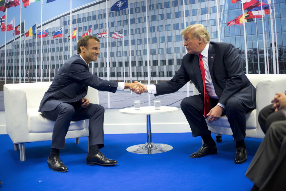 FILE - In this July 11, 2018 file photo, U.S. President Donald Trump and French President Emmanuel Macron shake hands during their bilateral meeting in Brussels, Belgium. EU foreign policy is widely expected to change to meet anticipated future bruising, confrontational challenges. (AP Photo/Pablo Martinez Monsivais, File)