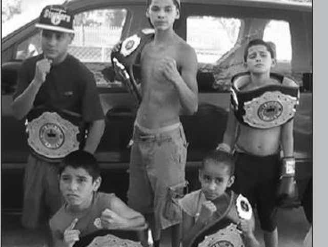 Danny Luna, bottom left, shows off a title belt won at an amateur boxing tournament competing in the 9- to 10 year-old division. Also pictured is Ryan Garcia, standing in the center.