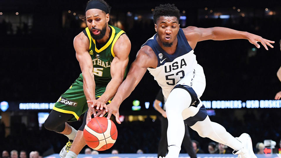 Patty Mills battles Team USA's Donovan Mitchell for the ball in the first exhibition game at Marvel Stadium. (Photo by Quinn Rooney/Getty Images)