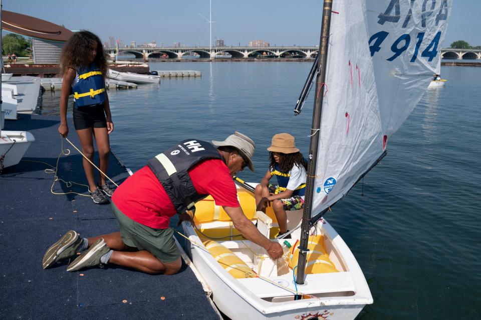 Kyla Foreman, 10, of Detroit, left, holds a rope at left and as Detroit Community Sailing Center president Harry Jones makes some adjustments for her and her crewmate Eleazar Smith, 10, of Detroit, on the Optimist (opti) boat that they will set sail in on the Detroit River as part of their participation in the Challenge the Wind program on Monday, July 24, 2023, from the banks of the Belle Isle Boat House.