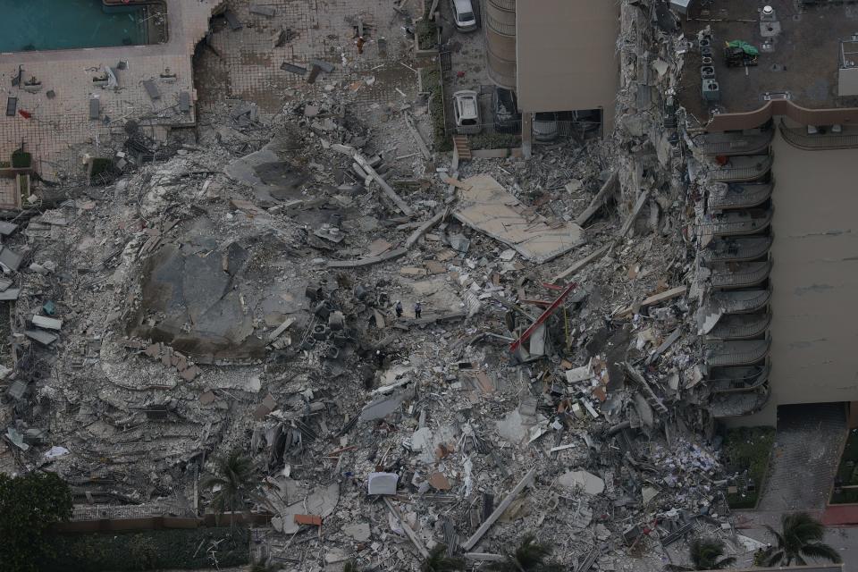 Search and rescue personnel work in the rubble of the 12-story condo tower that crumbled to the ground.