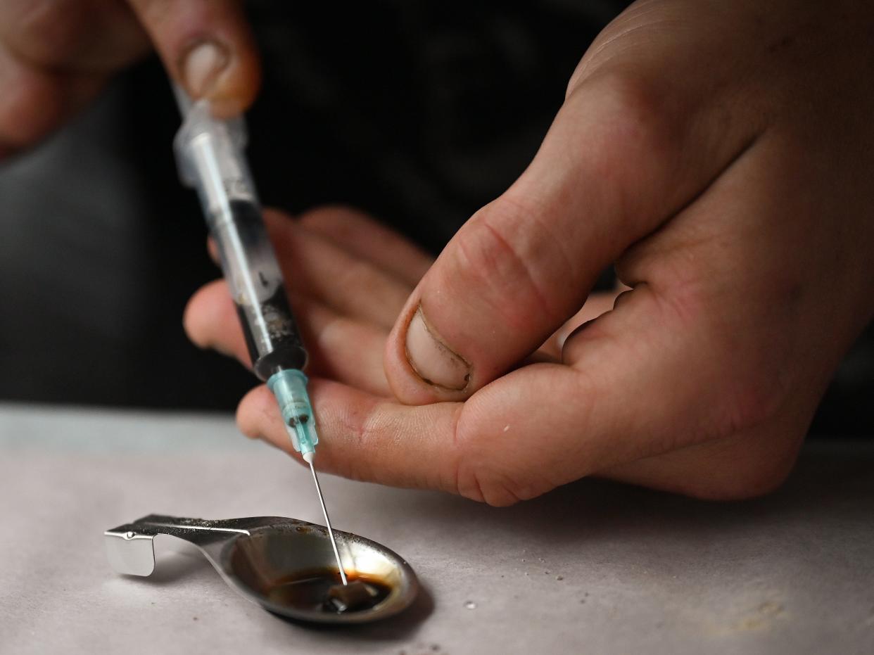 Drug users prepare heroin before injecting, inside of a Safe Consumption van set up by Peter Krykant (Jeff J Mitchell/Getty Images)