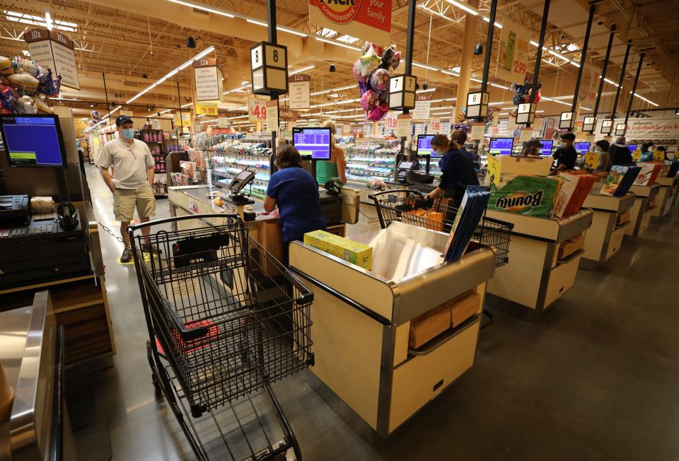 Cashiers checkout customers at Wegmans in Harrison on Aug. 5, 2020.