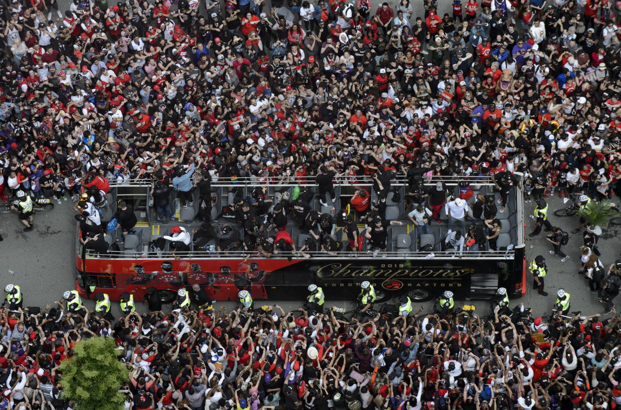 Fans cheer during the Toronto Raptors NBA basketball championship victory parade in Toronto, Monday, June 17, 2019. (Andrew Lahodynskyj/The Canadian Press via AP)