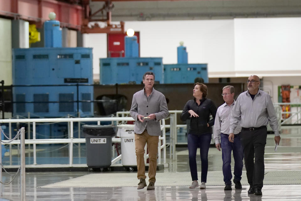 FILE - Gov. Gavin Newsom, left, tours the Edward Hyatt Power Plant at the Oroville Dam with Department of Water Resources Director Karla Nemeth, second left, in Oroville, Calif., Tuesday, April 19, 2022. California energy leaders said Friday, May, 6, 2022 that the state may see an energy shortfall this summer. Newsom toured the hydroelectric facility and discussed how the drought can hamper power generation. (AP Photo/Rich Pedroncelli, File)