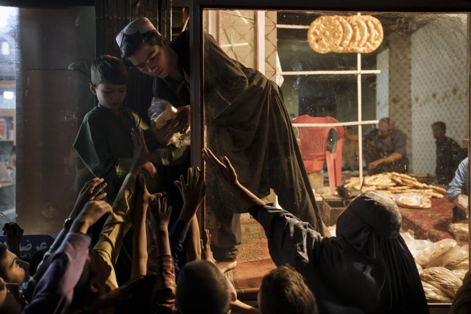 Afghan children and women gather outside a bakery to get free bread in Kabul, Afghanistan, Friday, Sept. 24, 2021. (AP Photo/Felipe Dana)