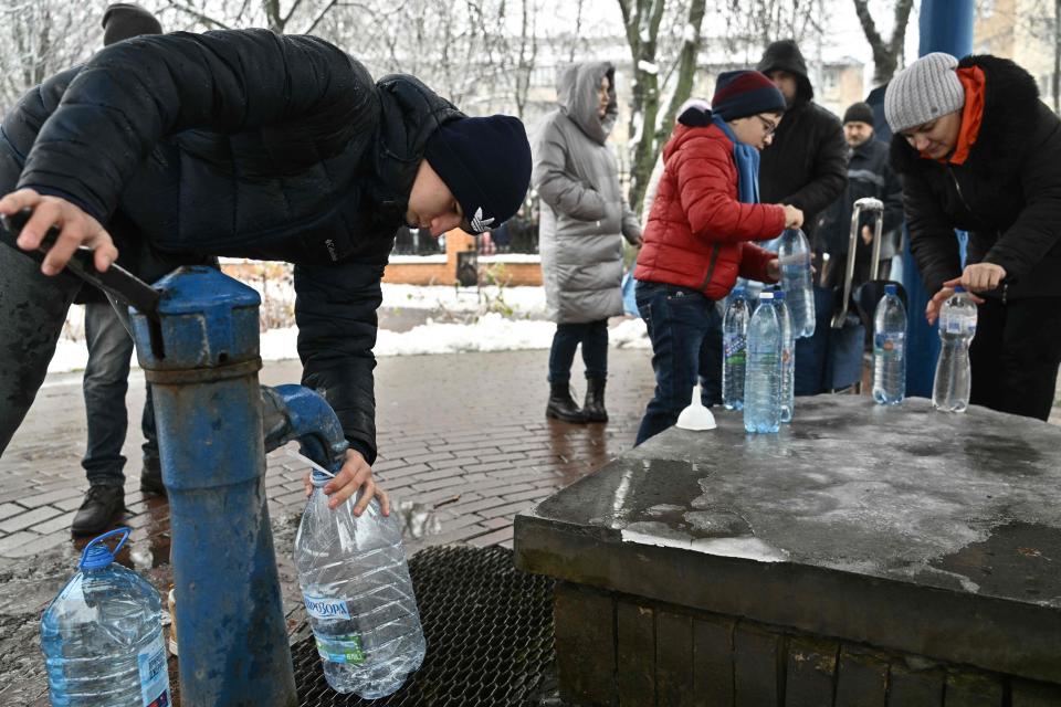 Kyiv residents fill plastic bottles at a water pump in a park in Kyiv (AFP via Getty Images)